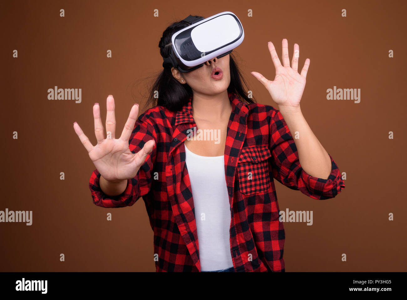 Gerne asiatische Frau mit VR-Brille für die virtuelle Realität spielen Stockfoto