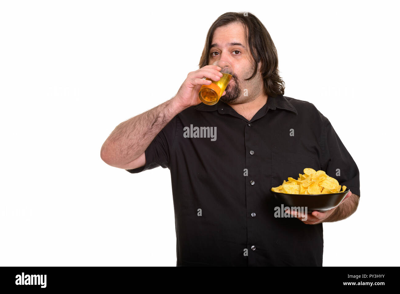Fat kaukasischen Mann Bier trinken, während Sie Schüssel Chips Stockfoto