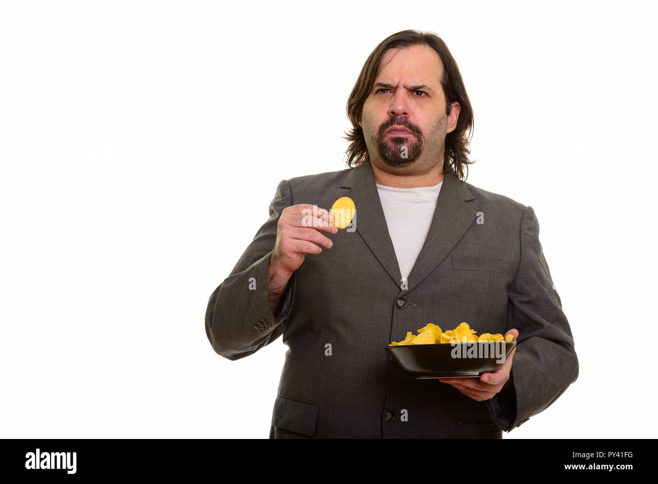 Fat kaukasischen Geschäftsmann holding Schüssel Chips und Denken Stockfoto