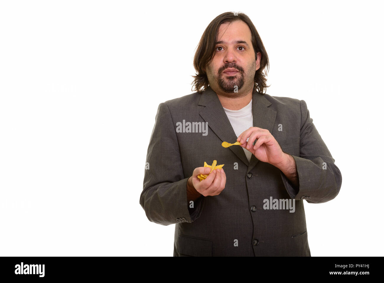 Fat kaukasischen Geschäftsmann essen Schluck von Chips Stockfoto
