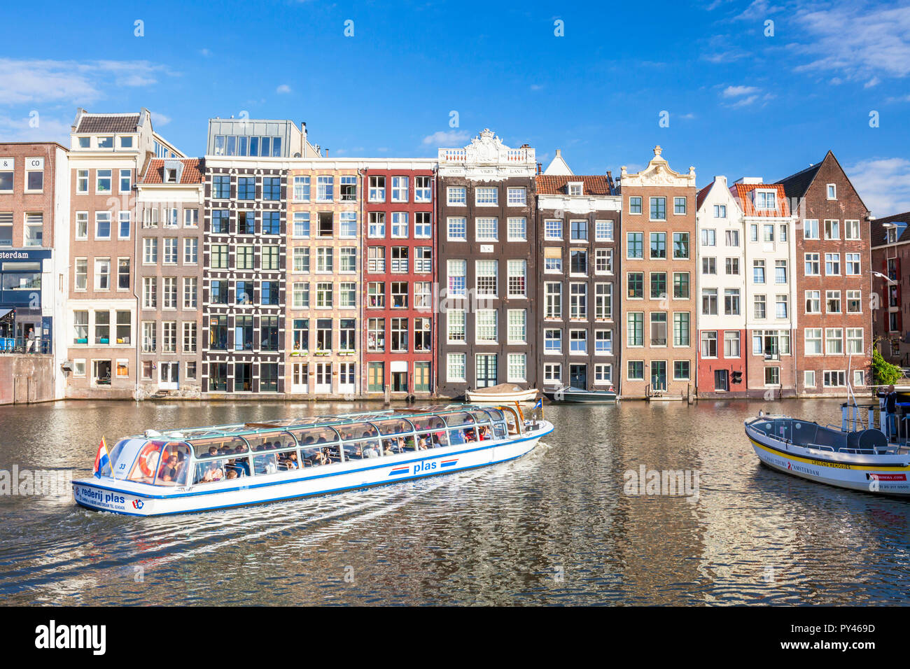 Amsterdam Häuser in der Damrak Häuser mit holländische Architektur durch den Kanal Der Kanal Boot verlassen Damrak Amsterdam Holland EU Europa Stockfoto