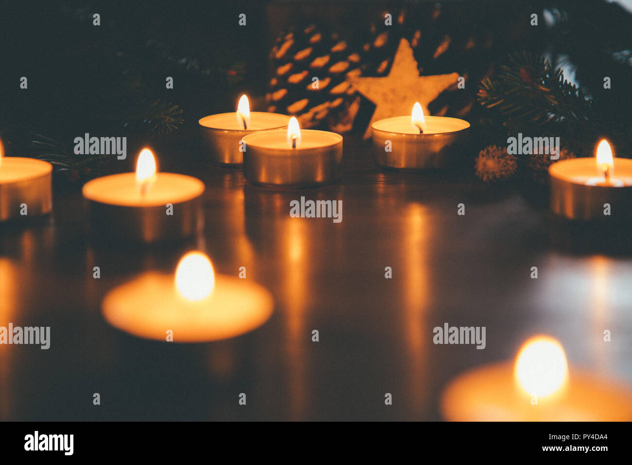 Brennen Weihnachten Kerzen auf dem Tisch mit Tannenzapfen, tannenzweigen, Dekoration und Beleuchtung. Filmkorn Effekt hinzugefügt Stockfoto