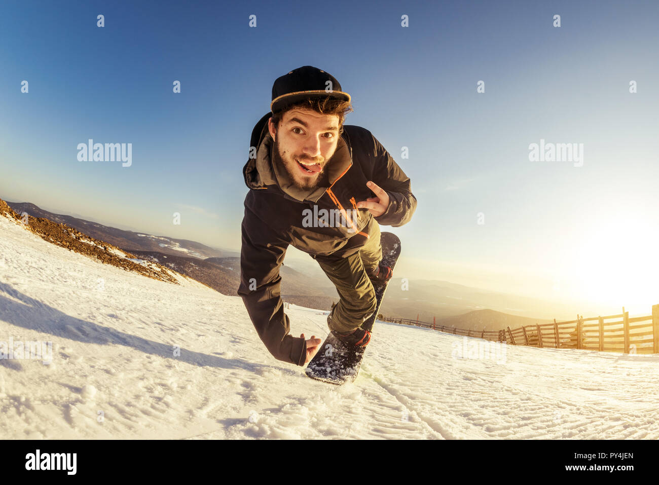 Junger Mann snowboarder springt und Macht spielerisch Trick Stockfoto