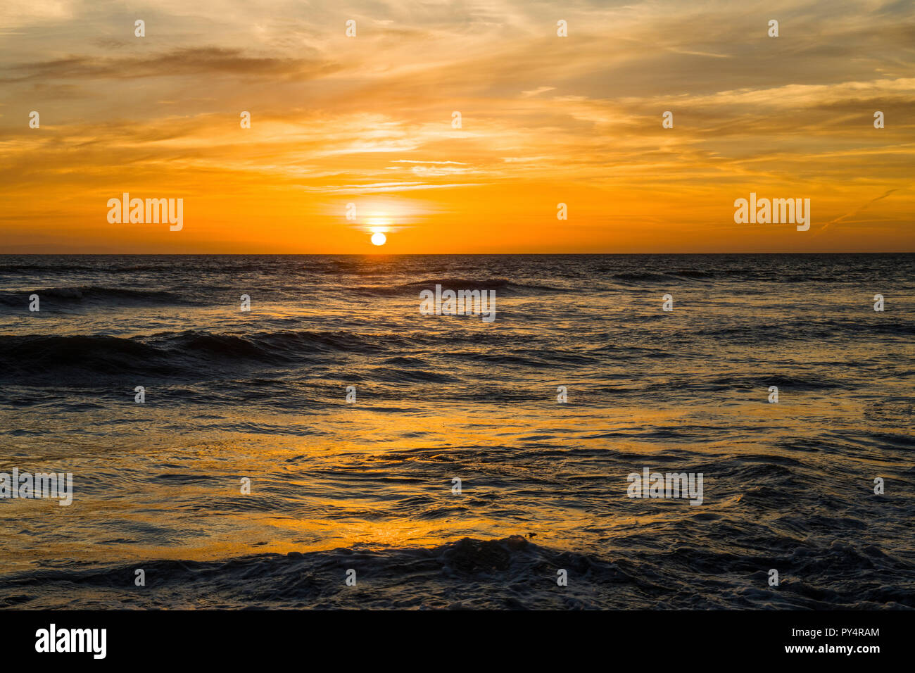 Die Sonne über llantwit Major Strand mit schönen orange Farben über das Meer widerspiegeln, an der Glamorgan Heritage Coast, South Wales Stockfoto
