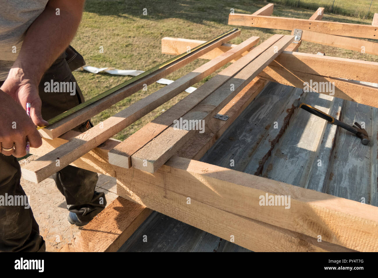 Dachkonstruktion Gebäude. Mann messen Elemente mit Maßband oder Schaufel. Stockfoto