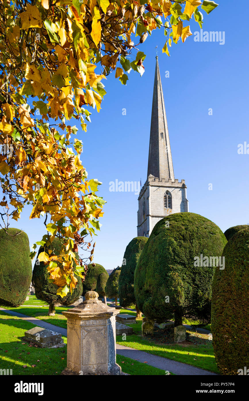 Painswick St Mary's Pfarrkirche mit herbstlich gefärbten Bäumen am Nachmittag, Sonnenschein, Painswick, Cotswolds, Gloucestershire, England, Vereinigtes Königreich Stockfoto