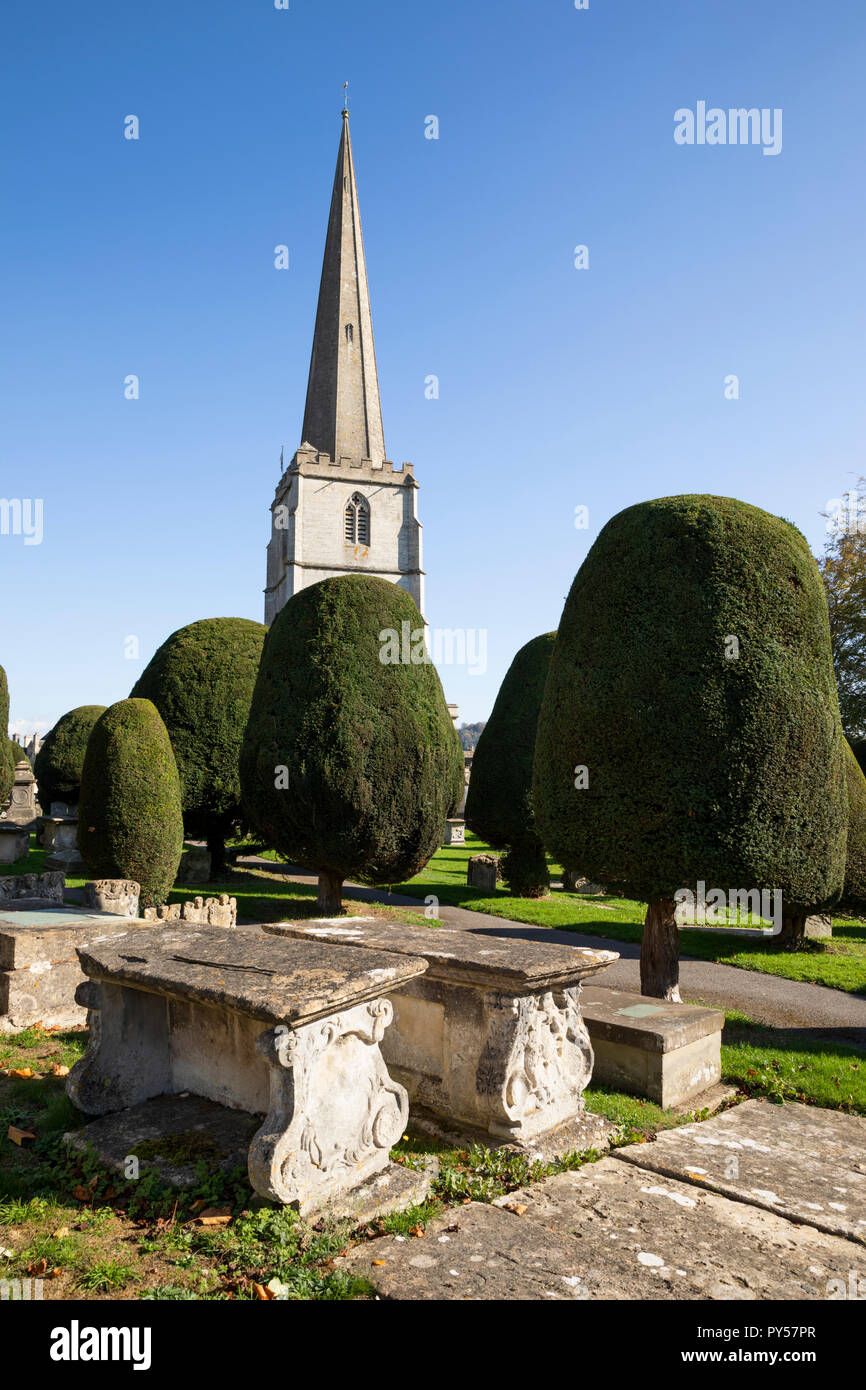 St Mary's Pfarrkirche mit Eiben und Brust Gräber auf dem Friedhof in Nachmittag Sonnenschein, Painswick, Cotswolds, Gloucestershire, England, Großbritannien Stockfoto