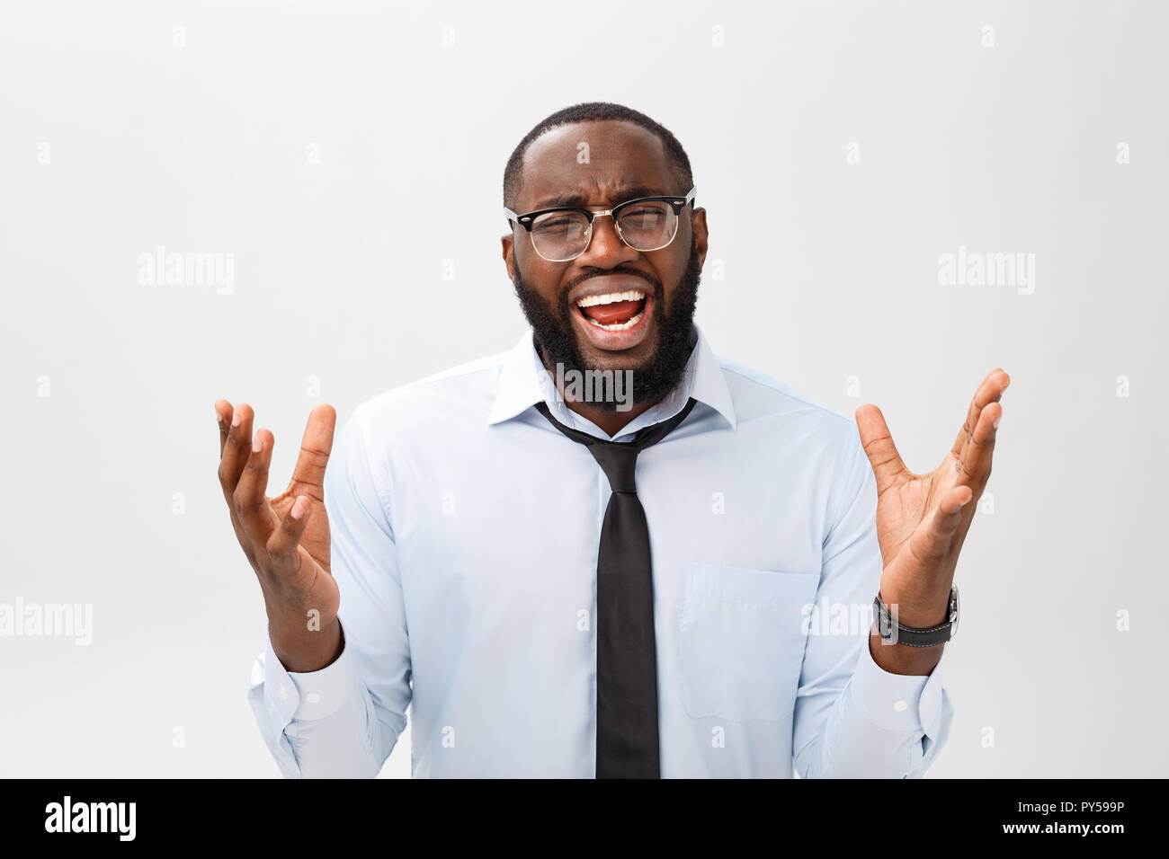 Portrait von verzweifelten genervt männlichen Schwarzen schreiend in Wut und Zorn seine Haare reißen aus, während das Gefühl wütend und Mad mit etwas. Negative menschliche Gesicht Ausdruck, Emotionen und Gefühle. Stockfoto