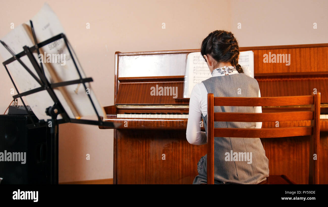 Ein kleines Mädchen Klavier spielen auf Musik Lektion. Ansicht von hinten  Stockfotografie - Alamy