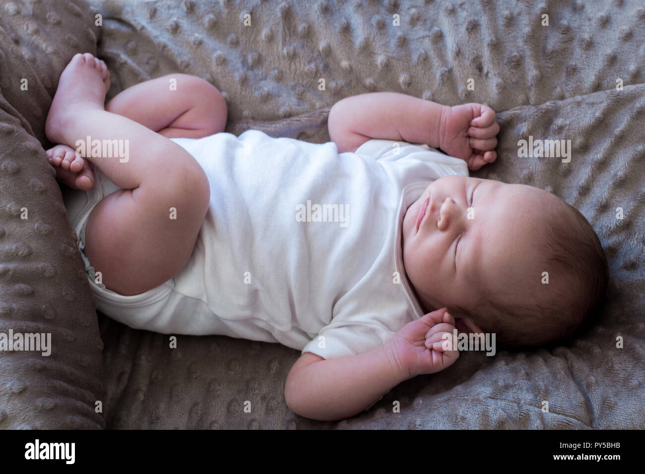 Neugeborene schlafen auf dem Rücken top Aussicht in voller Länge tragen ein weißes Hemd mit kurzen Ärmeln. Stockfoto