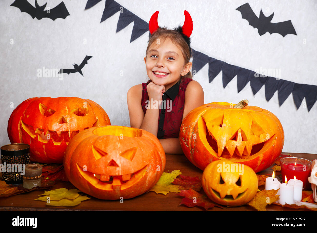 Happy Halloween. Lustige kleine Kind Mädchen mit dem Schnitzen Kürbis Süß. Glückliche Familie Vorbereitungen für Halloween. Stockfoto