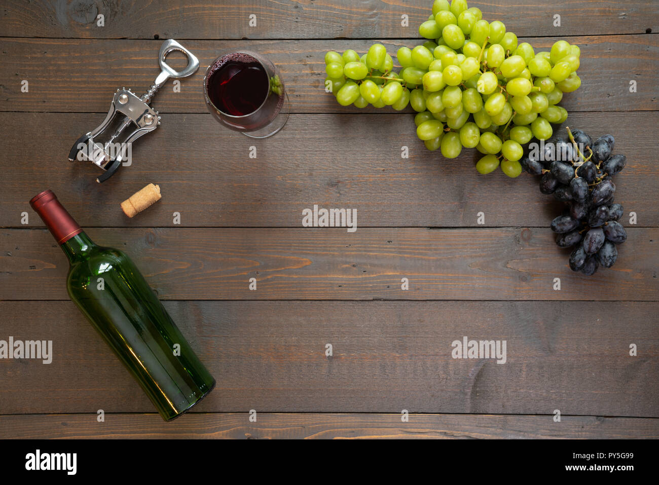 Glas Rotwein mit Flasche Wein und Trauben Stockfoto