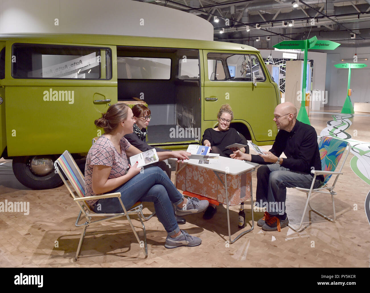 Dortmund, Deutschland. 25 Okt, 2018. Ria Glaue (L-R), Luisa Kern, Magdalena Roß und Philipp Horst sitzen vor dem VW-Bus in der interaktiven Mobilität Ausstellung 'Stop and Go" in der DASA und Mobilität Bingo spielen. Vom 26.10. bis 14.07.2019, die Ausstellung auf die Mobilität unserer täglichen Fahrten mit dem Auto, dem Fahrrad, zu Fuß und mit Bus und Bahn in einem Adventure Kurs zeigen. Credit: Caroline Seidel/dpa/Alamy leben Nachrichten Stockfoto