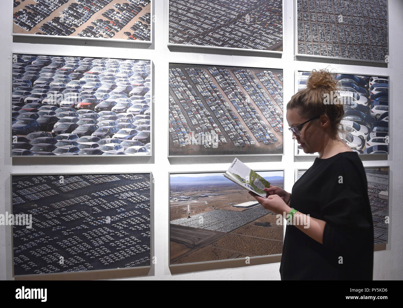 Dortmund, Deutschland. 25 Okt, 2018. Magdalena Roß steht vor Fotografien von David Goddard und Lucy Nicholson in der interaktiven Mobilität Ausstellung 'Stop and Go" in der DASA. Vom 26.10. bis 14.07.2019, die Ausstellung auf die Mobilität unserer täglichen Fahrten mit dem Auto, dem Fahrrad, zu Fuß und mit Bus und Bahn in einem Adventure Kurs zeigen. Credit: Caroline Seidel/dpa/Alamy leben Nachrichten Stockfoto