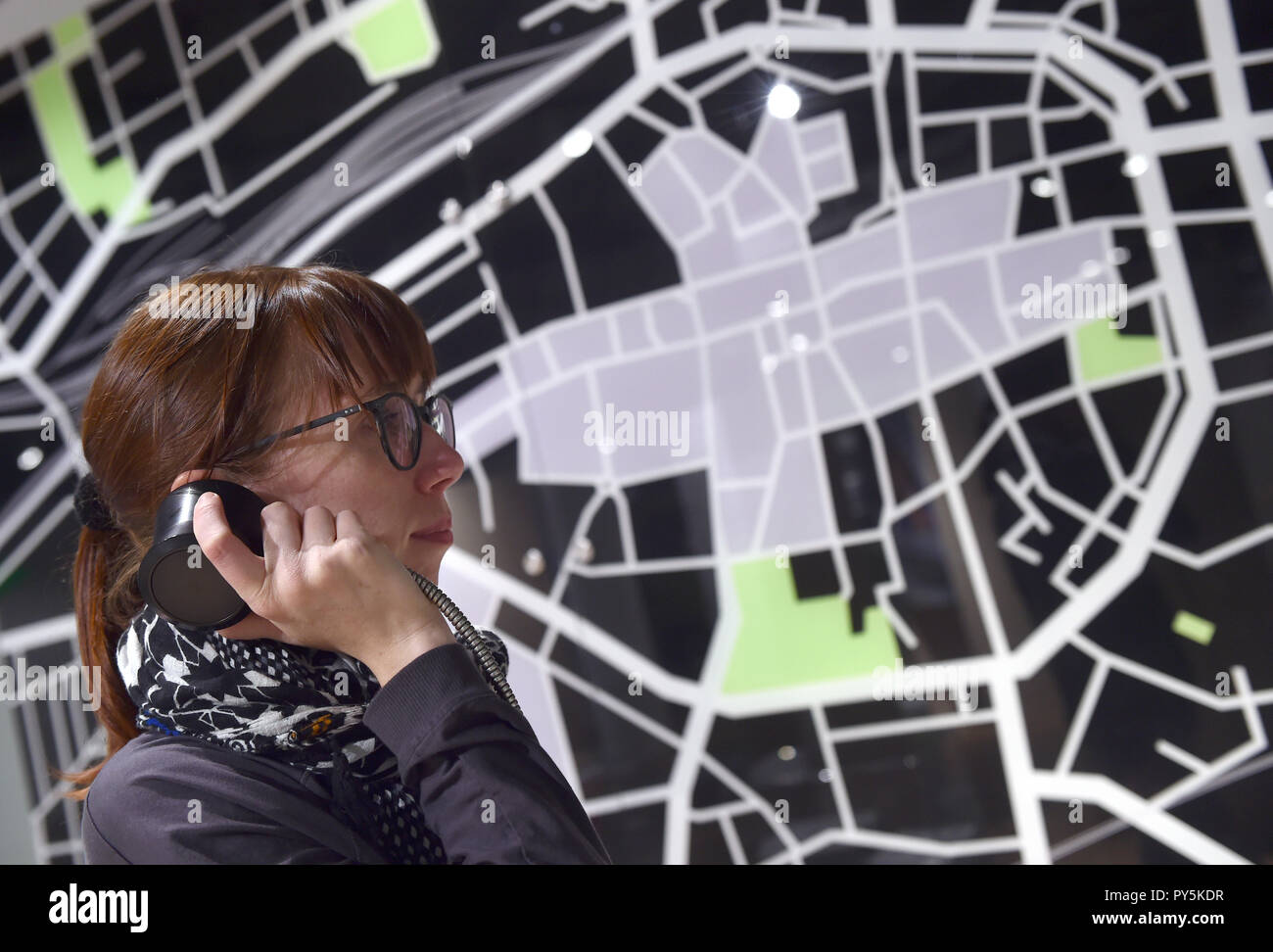 Dortmund, Deutschland. 25 Okt, 2018. Luisa Kern hört Informationen über die Ausstellung in der interaktiven Mobilität Ausstellung 'Stop and Go" in der DASA vor einem Stadtplan der Stadt Dortmund. Vom 26.10. bis 14.07.2019, die Ausstellung auf die Mobilität unserer täglichen Fahrten mit dem Auto, dem Fahrrad, zu Fuß und mit Bus und Bahn in einem Adventure Kurs zeigen. Credit: Caroline Seidel/dpa/Alamy leben Nachrichten Stockfoto