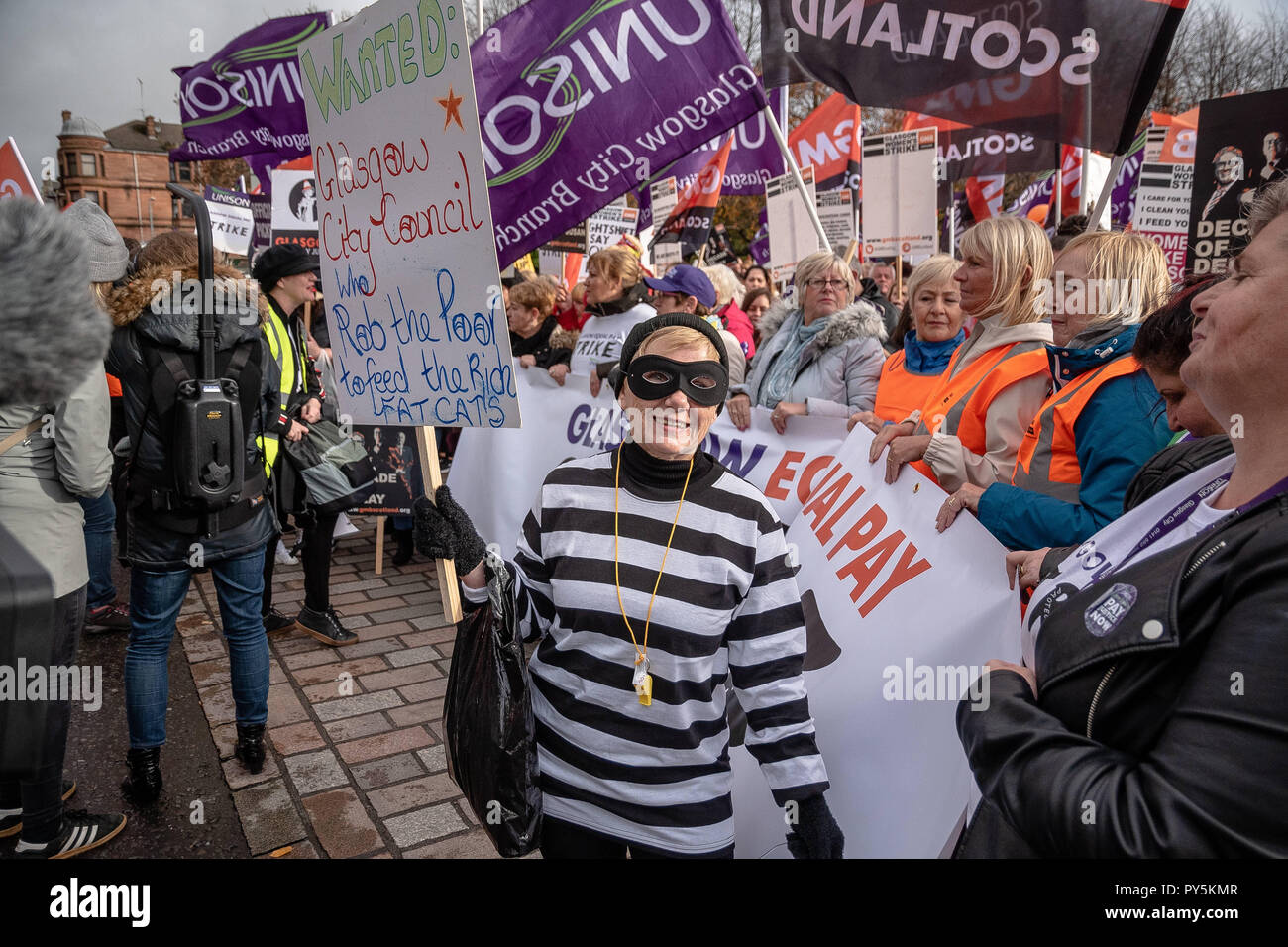 Glasgow, Renfrewshire, Großbritannien. 23 Okt, 2018. Eine Frau gesehen wird wie ein Räuber halten sie ein Plakat während des Streiks gekleidet. Tausende von weiblichen Beschäftigten von Glasgow City auf einen 48-stündigen Streik für empfängt nicht die gleiche Bezahlung und nicht die korrekte Löhne zu Ihnen ging, der Rat der Stadt vor 12 Jahren Nachzahlungen in Millionen von Pfund reichen. Credit: Stewart Kirby/SOPA Images/ZUMA Draht/Alamy leben Nachrichten Stockfoto