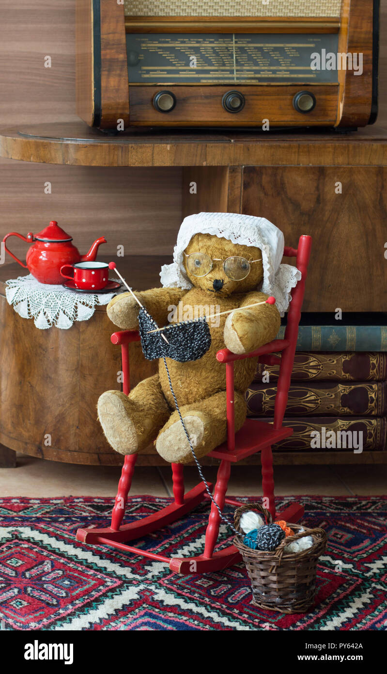 Teddybär oma Stricken in einem Schaukelstuhl in einem vintage Innenraum Stockfoto