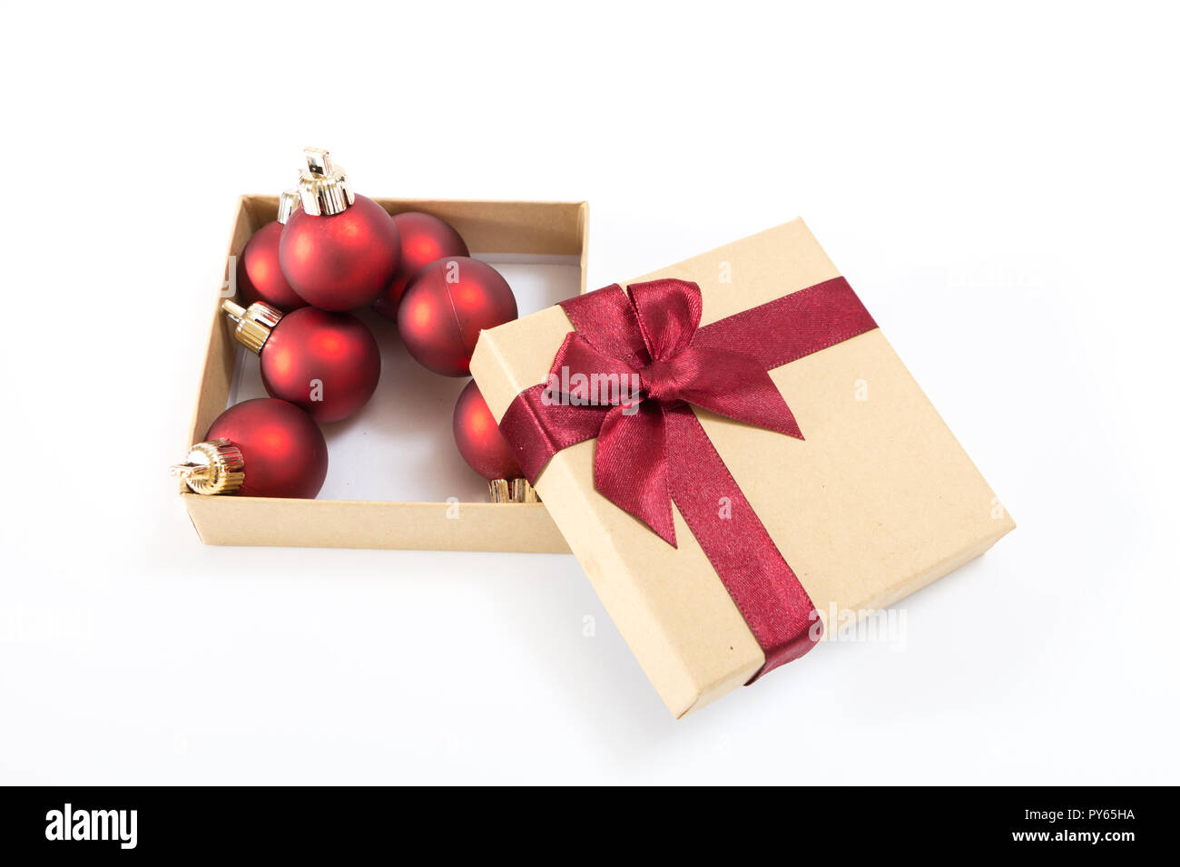 Papier Geschenkbox mit roter Schleife und Weihnachtskugeln, auf weißem Hintergrund. Stockfoto