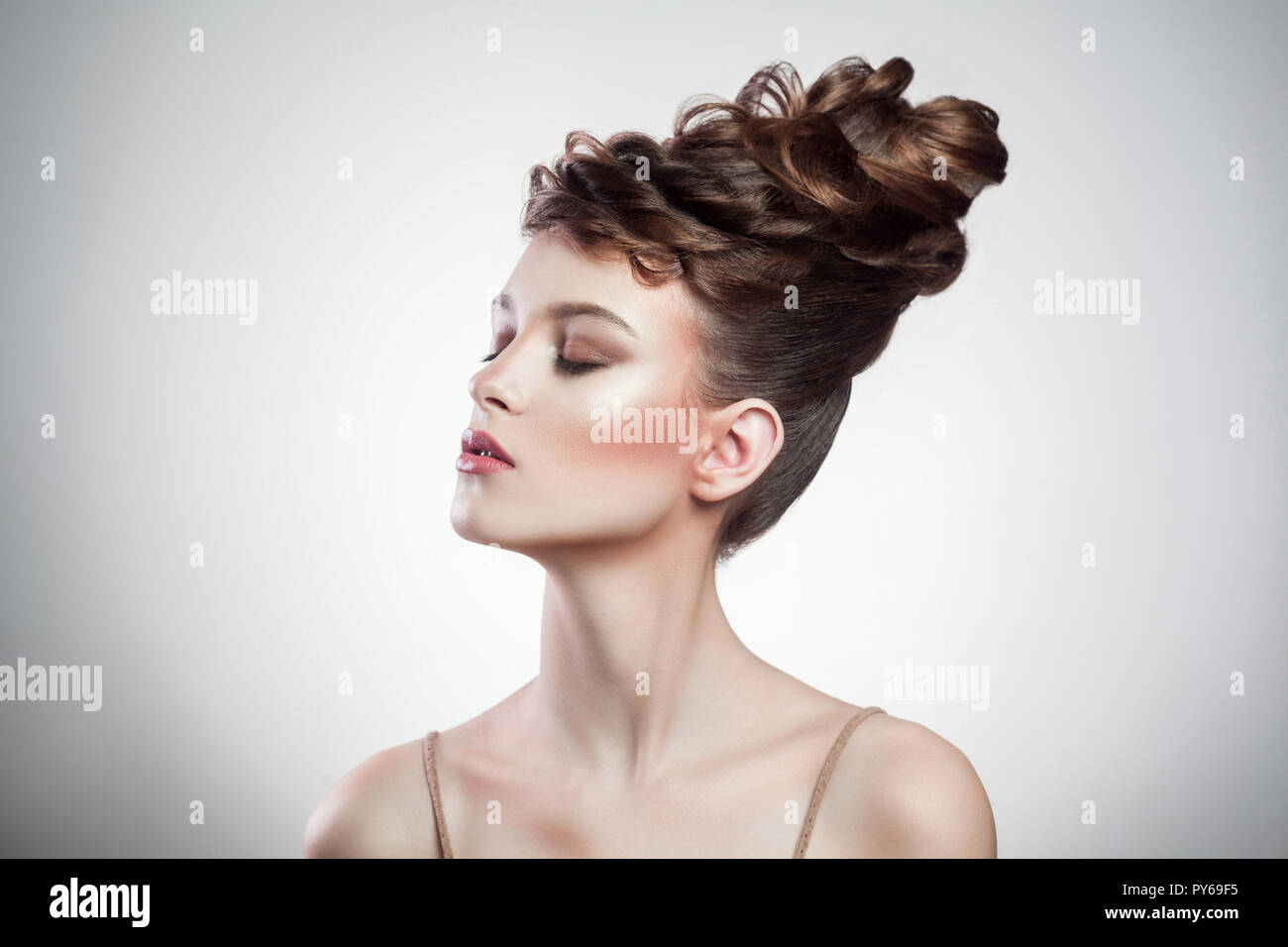Portrait von attraktiven brünette Frau mit stilvolle Frisur und Make-up mit geschlossenen Augen auf dem isolierten grauer Hintergrund posiert. Indoor, studio Schuß auf Kopieren Stockfoto