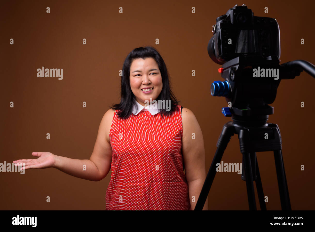 Übergewicht asiatische Frau vlogging im Studio mit DSLR-Kamera auf Stativ Stockfoto