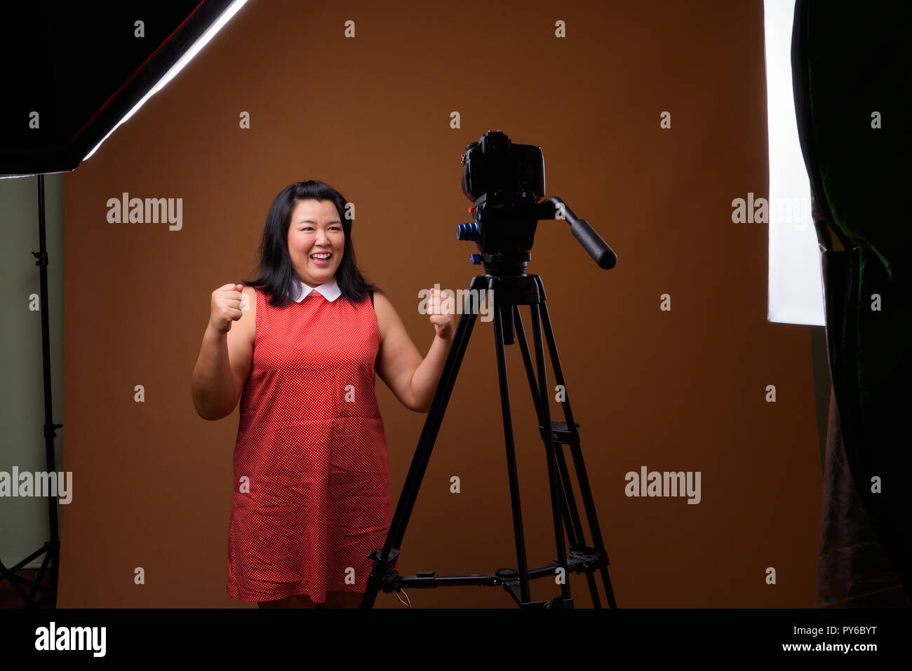 Übergewicht asiatische Frau vlogging im Studio mit DSLR-Kamera auf Stativ Stockfoto