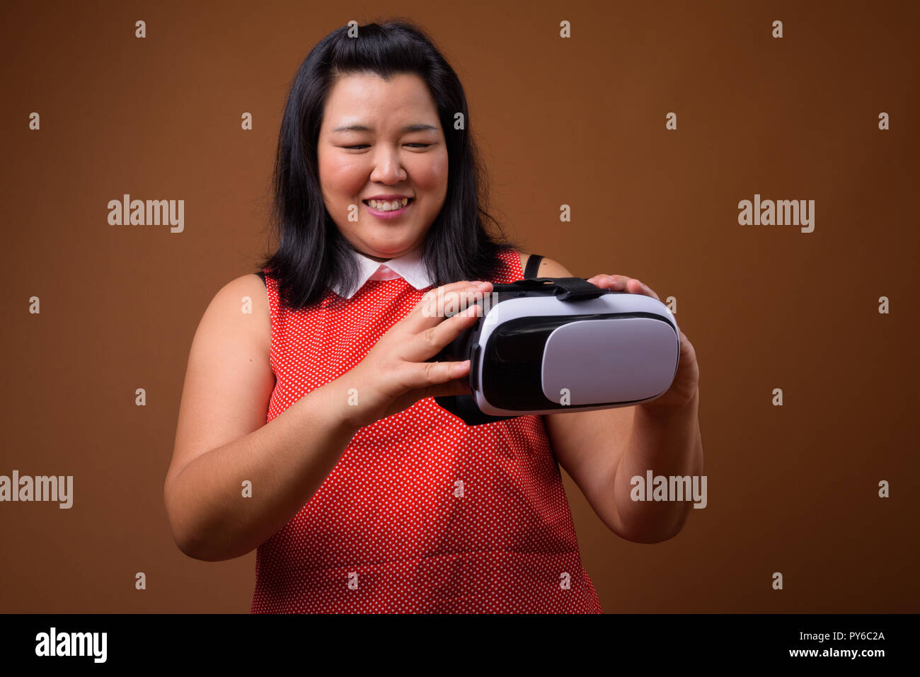 Schöne Übergewicht asiatische Frau mit Virtual Reality VR-Brille während lächelnd Stockfoto