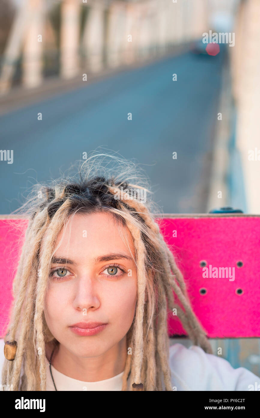 Schöne junge Frau mit rosa Skateboard portrait Stockfoto