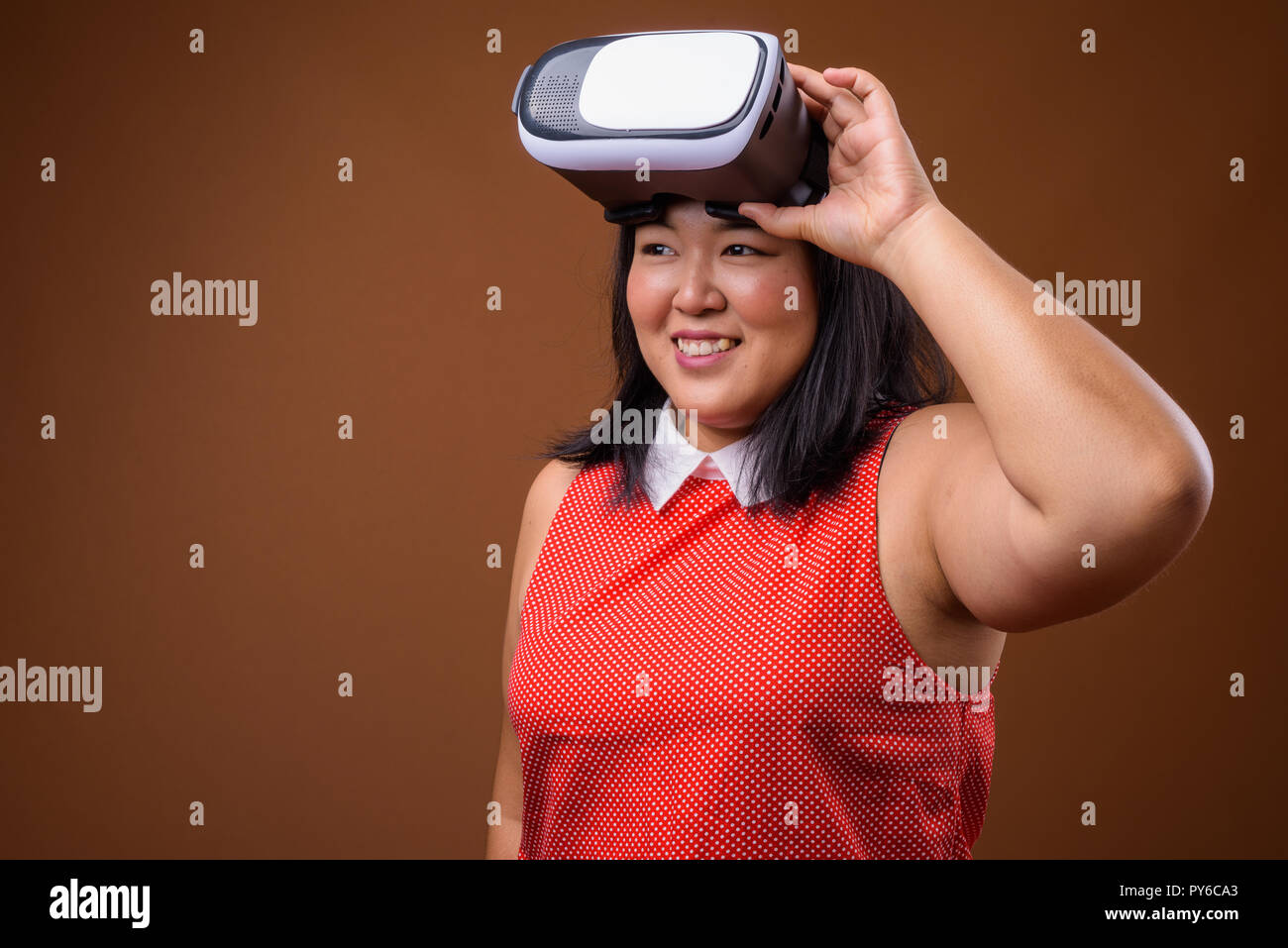 Portrait von asiatische Frau mit Virtual Reality VR-Brille während lächelnd Stockfoto