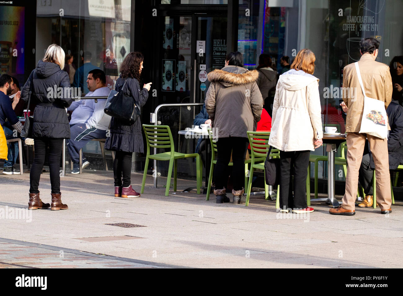 Eine Gruppe von Menschen versammelt, um gemeinsam außerhalb der Costa Coffee Shop Kaffee trinken und plaudern miteinander in Dundee, Großbritannien Stockfoto