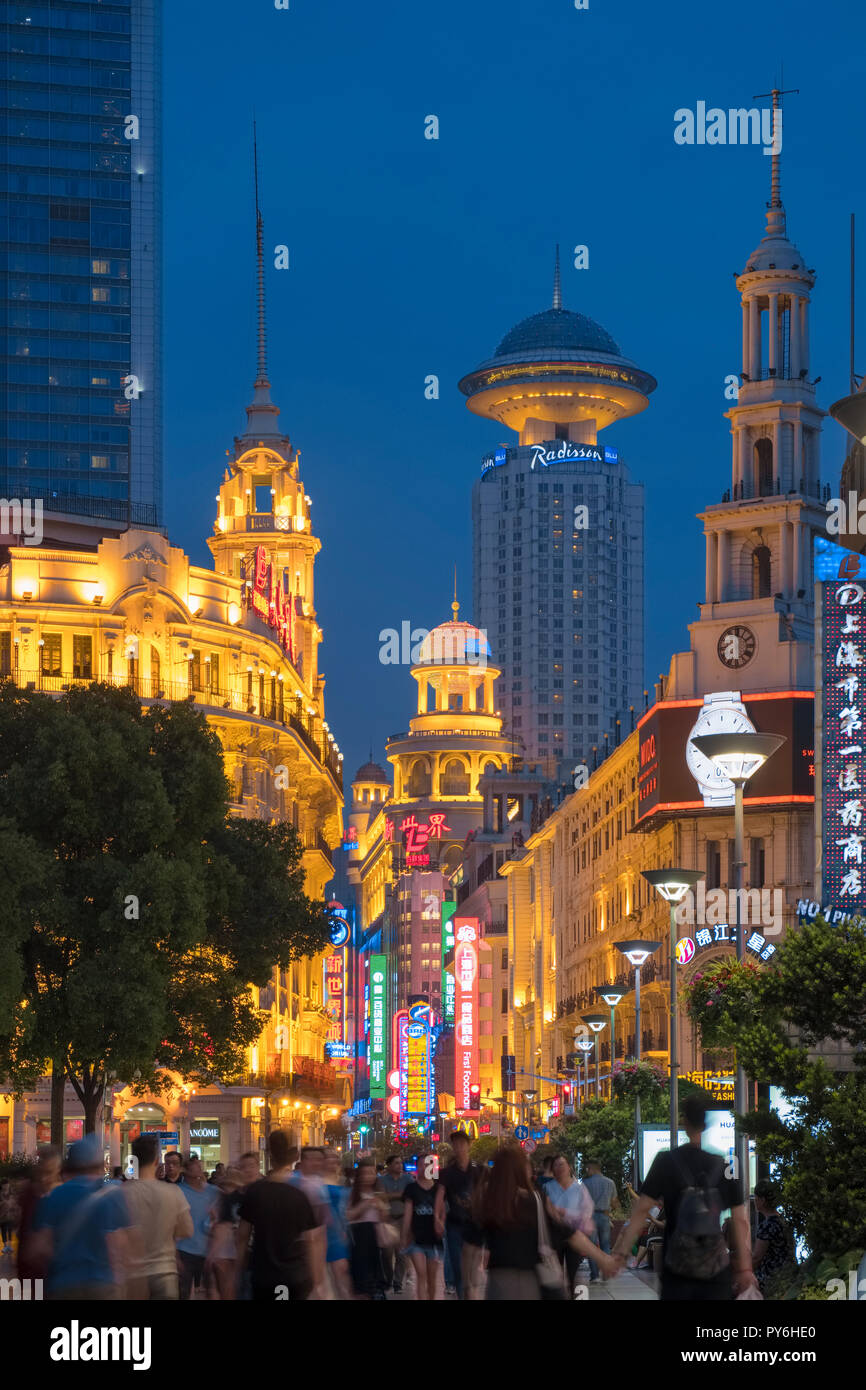 Masse der Leute gegen die Skyline von Shanghai entlang einer belebten überfüllt, die Nanjing Road West, Shanghai, China, Asien bei Nacht Stockfoto