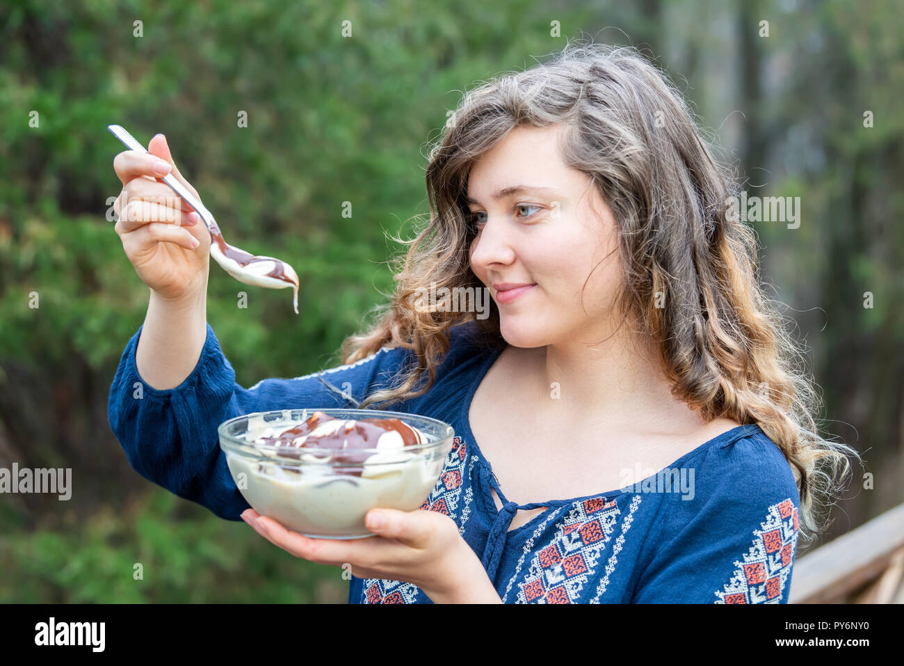 Junge Frau, Draußen, Draußen, holding Glas Schale hausgemachter, Raw vegan Vanilleeis mit flüssiger Schokolade Soße, Löffel, bereit zu essen Stockfoto