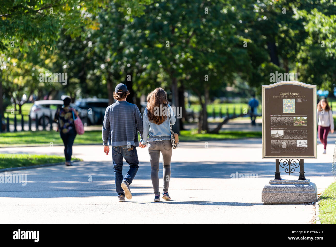 Washington DC, USA - Oktober 12, 2018: Der junge Paar im Capitol Square Park halten sich an den Händen während der sonnigen Herbsttag von US-Kongress auf der Kappe Stockfoto