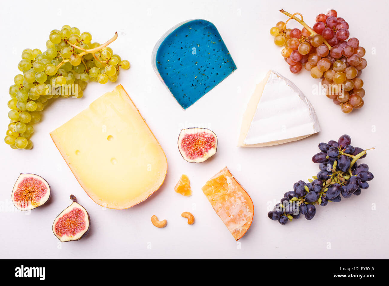 Verschiedene Käse mit Nüssen und Trauben auf dem Tisch. Ansicht von oben Bild von weichen und harten Käse Stockfoto