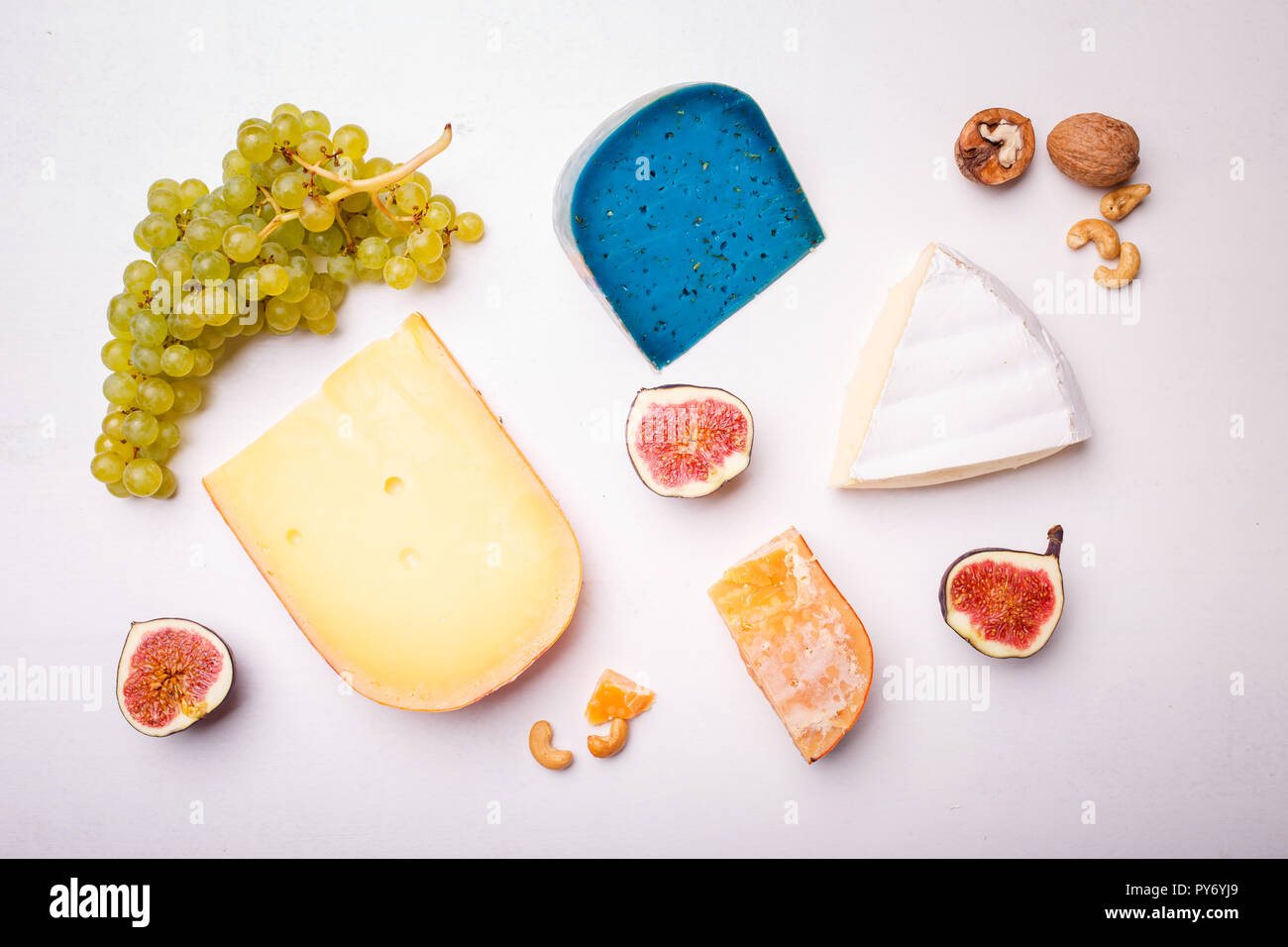 Verschiedene Käse mit Nüssen und Trauben auf dem Tisch. Ansicht von oben Bild von weichen und harten Käse Stockfoto