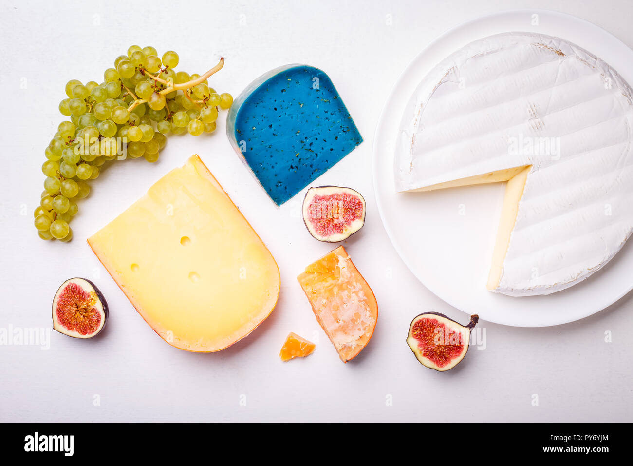 Verschiedene Käse mit Nüssen und Trauben auf dem Tisch. Ansicht von oben Bild von weichen und harten Käse Stockfoto