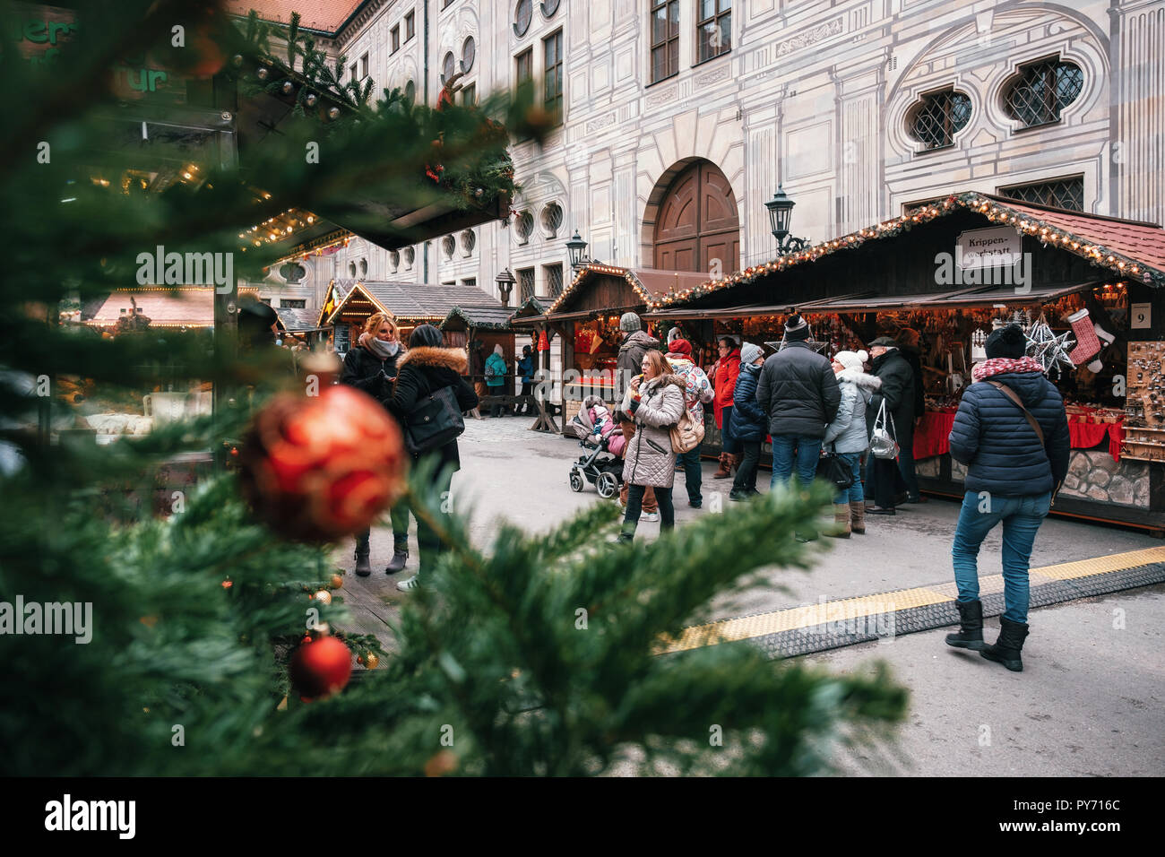Munich, Bayern, Deutschland - Dezember 6, 2017: Weihnachtsbaum oder Tannenzweigen auf Weihnachtsmarkt in Deutschland mit entspannenden Menschen in Urlaub Stockfoto