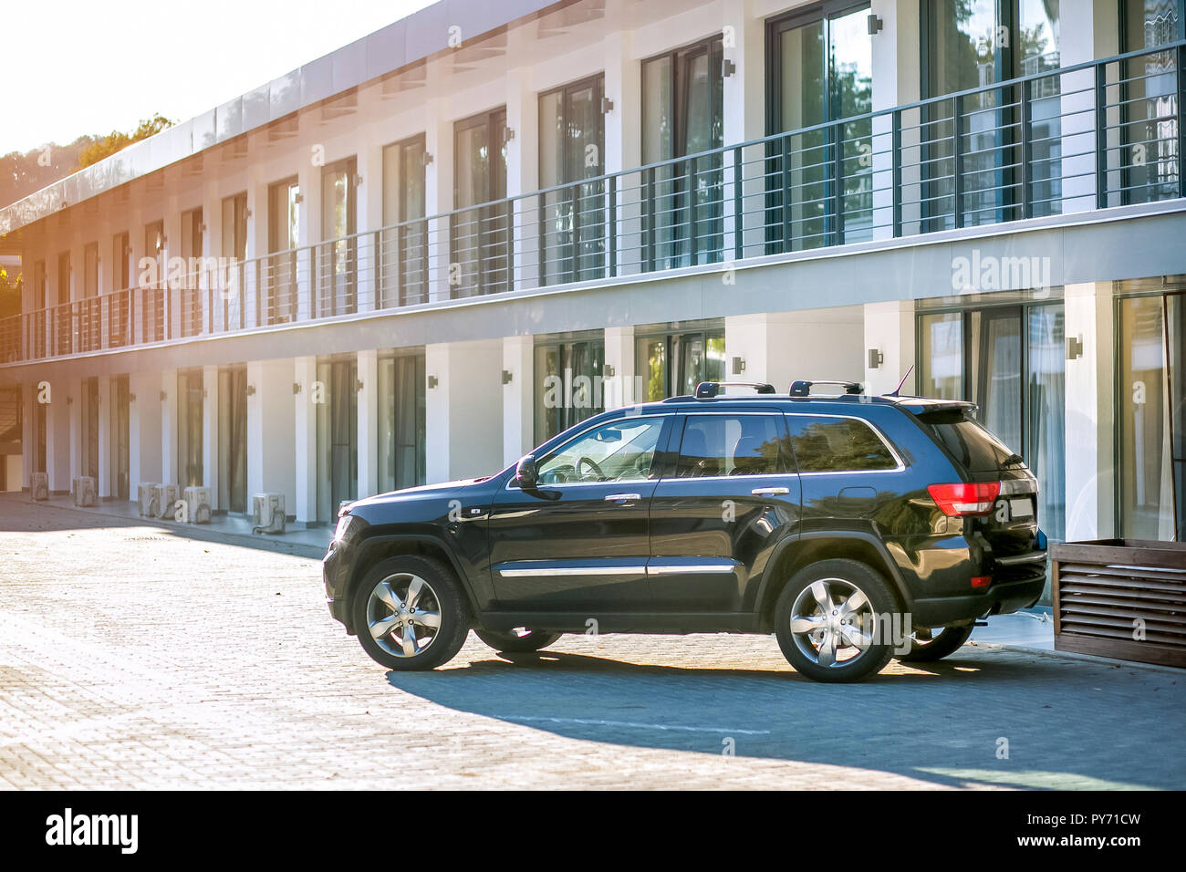 Schwarzen SUV auf einem speziellen Bereich vor einer neuen Stadthaus an einem sonnigen Sommerabend geparkt. Außerhalb Foto Stockfoto