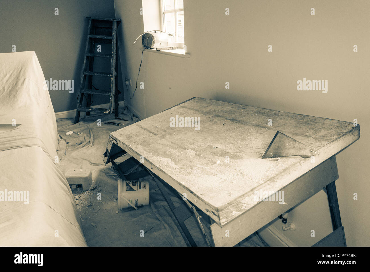 Authentische Situation: Gebrochene Leiter in der Ecke des Zimmers verursachte einen Unfall, bei dem ein Maler und Dekorateur fielen auf die tapezieren Tabelle, brach eine Stockfoto