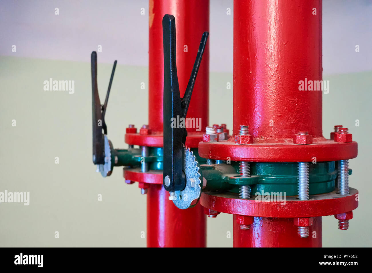 Schieber auf Rohren in Rot lackiert installiert. Industrielle Hintergrund. Stockfoto