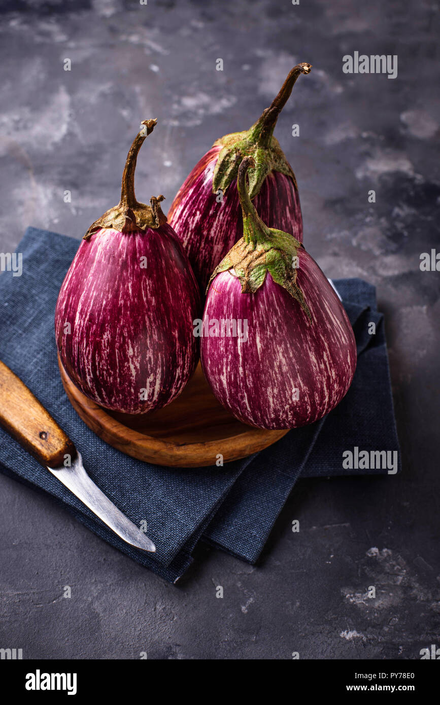 Frisch gestreift lila Auberginen auf grauem Hintergrund Stockfoto