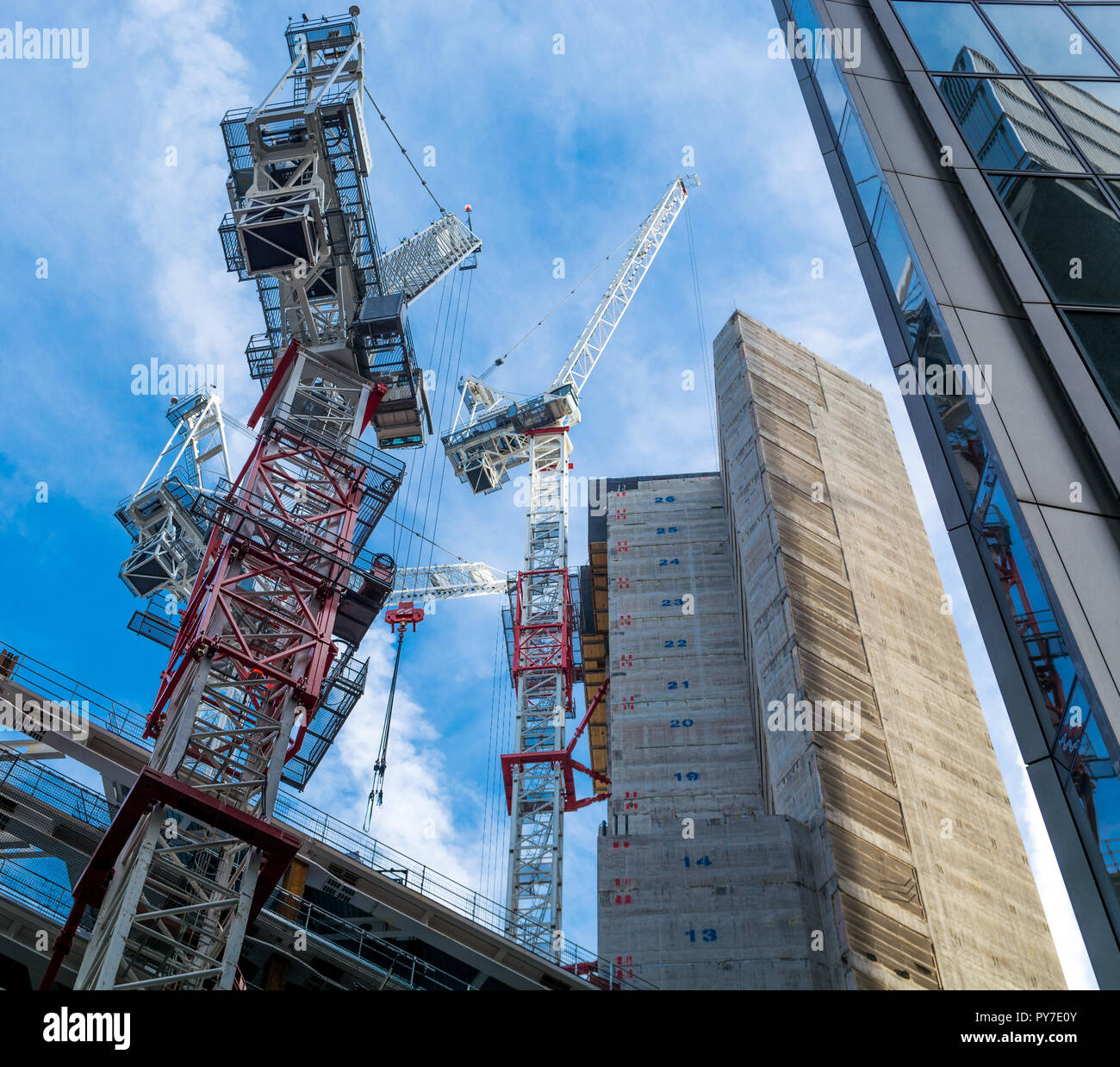 Drei Turmdrehkranen auf der Baustelle in der Londoner City vor blauem Himmel Stockfoto