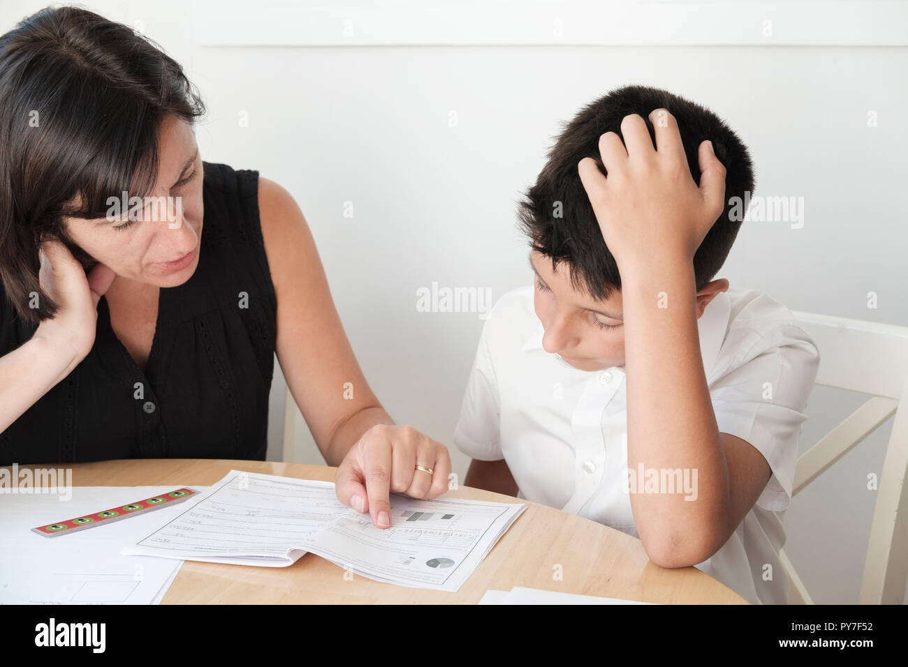 UK, Mutter hilft, 11 Jahre alter Junge mit Prüfungen Revision Stockfoto