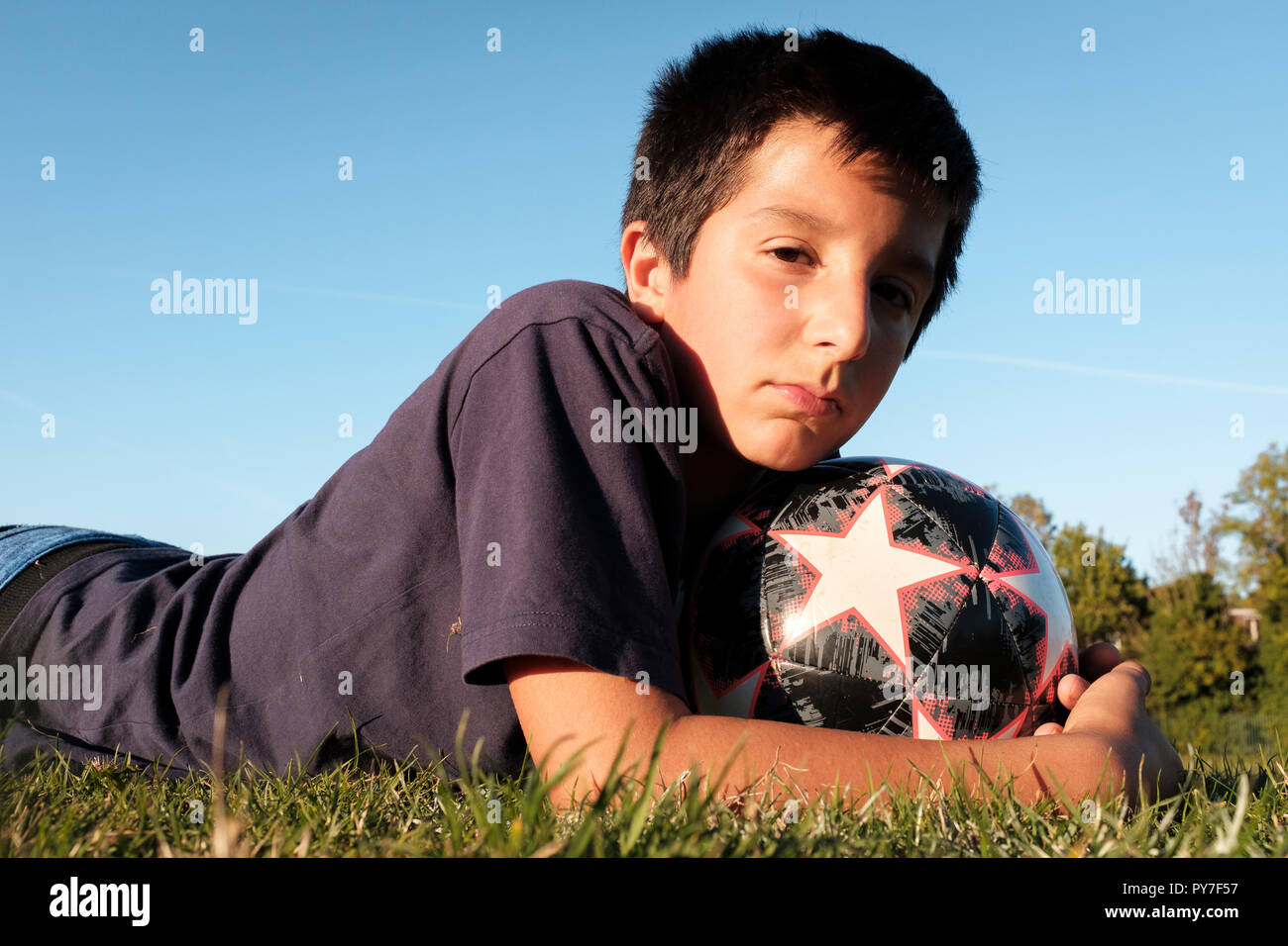 UK, 11 Jahre alter Junge halten eine Fußball-Ball im Freien Stockfoto