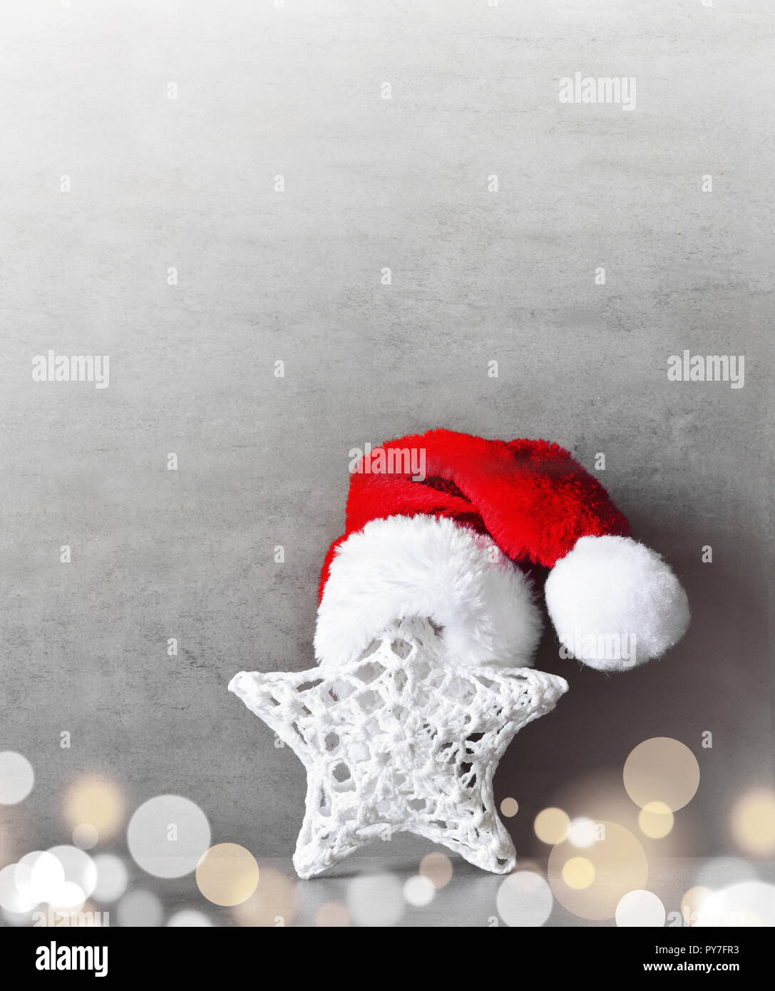 Weihnachtsdekor Stern mit Santa hat. Grauer Hintergrund. Stockfoto