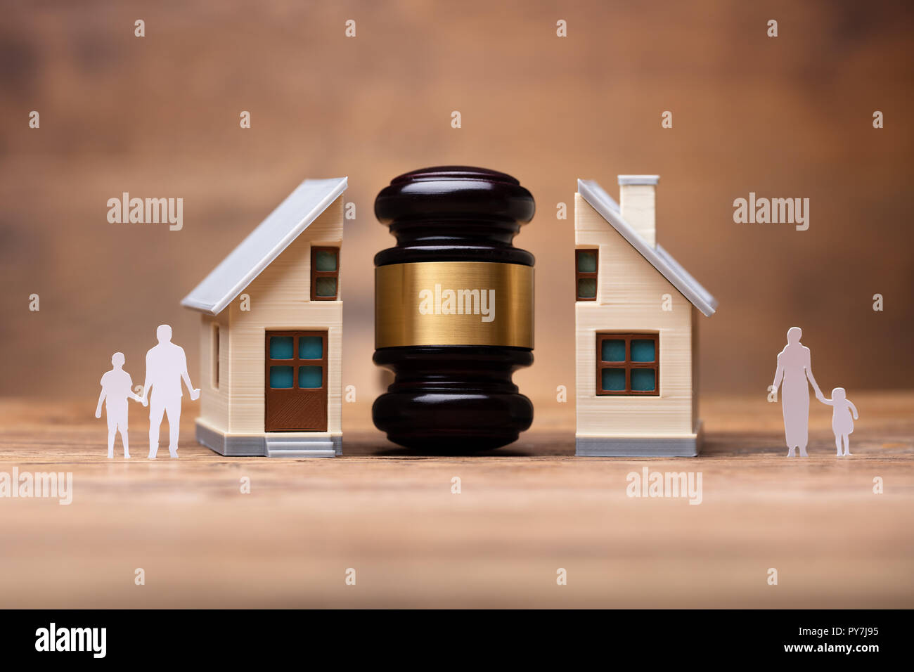 In der Nähe von Hammer zwischen Split Familie Zahlen und Haus Modell auf hölzernen Schreibtisch Stockfoto