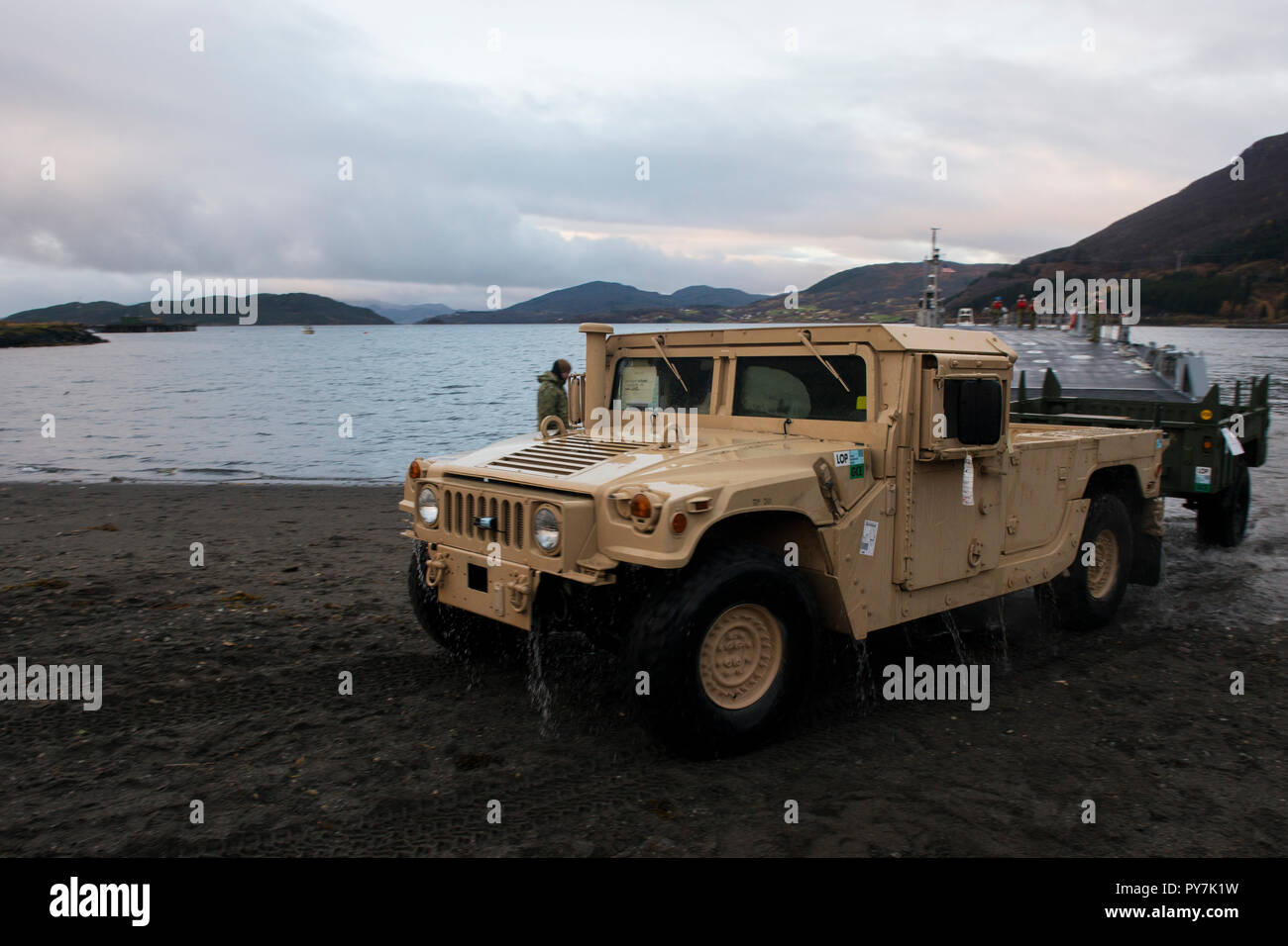 181019-N-VO 150-0819 (Okt. 2010) 19, 2018) Marines aus II Marine Expeditionary Force Drive a High Mobility Multipurpose Radfahrzeug (Hmmwv) aus einer verbesserten Marine Ligtherage System (INLS) Causeway Fähre, von Amphibischen Bau Bataillon 2 betrieben, nach Stechen den Strand während der Maritimen Vorpositionierung Kraft Abladen der USNS 1 Lt Baldomero Lopez (T-AK 3010) während der Übung Northern Bildschirm in Bogen, Norwegen, Okt. 19, 2018. Northern Bildschirm ist eine bilaterale Übung für das United States Marine Corps' Marine Rotational Force-Europe (MRF-E) und das norwegische Militär, und statt. Stockfoto