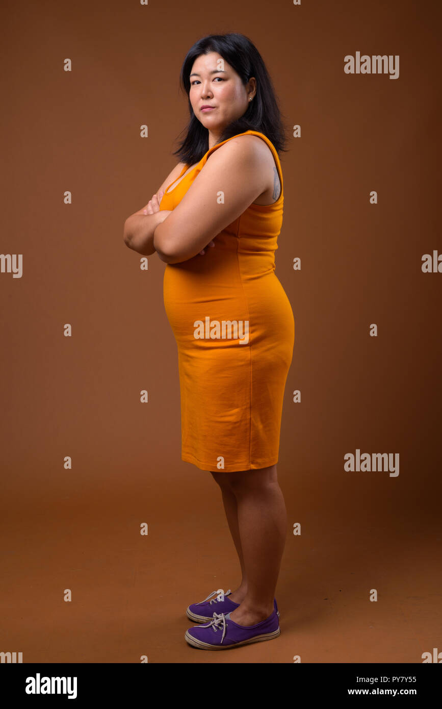 Volle Länge Profil anzeigen Der übergewichtigen Frau mit gekreuzten Armen Stockfoto