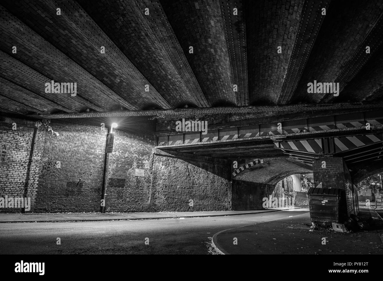 Eine lange Exposition Rahmen eines Fahrzeugs, wie es verläuft unter der Eisenbahnbrücke über Grey Street in Ardwick, Manchester am 11. Oktober 2018. Stockfoto