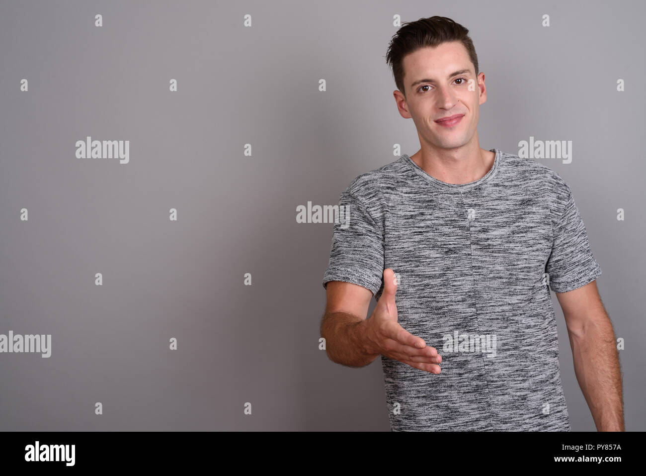 Jungen gutaussehenden Mann, der Händedruck und Kamera Stockfoto