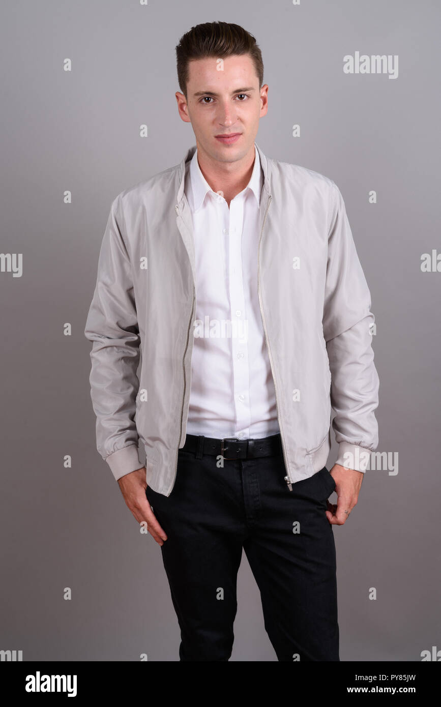 Jungen gutaussehenden Mann mit Jacket gegen grauer Hintergrund Stockfoto